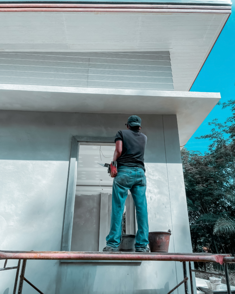 Guy painting the exterior of a house